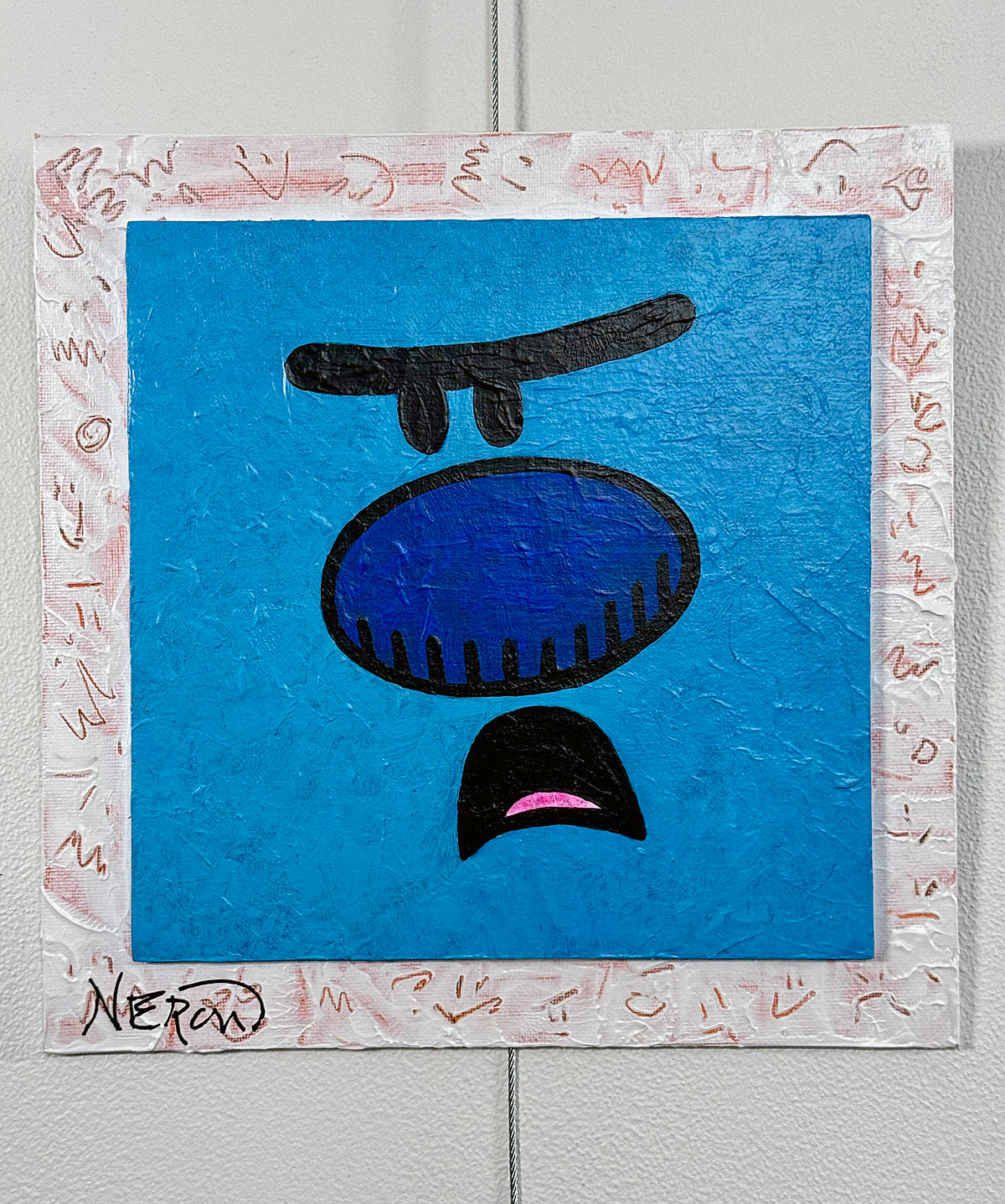 Square artwork titled “Mr. Grumpy” by Audrey Néron, featuring a minimal pop-style blue character on a white 10×10 in panel. Acrylic and graphite with clean bold lines, Pop Pop Series, 2025.