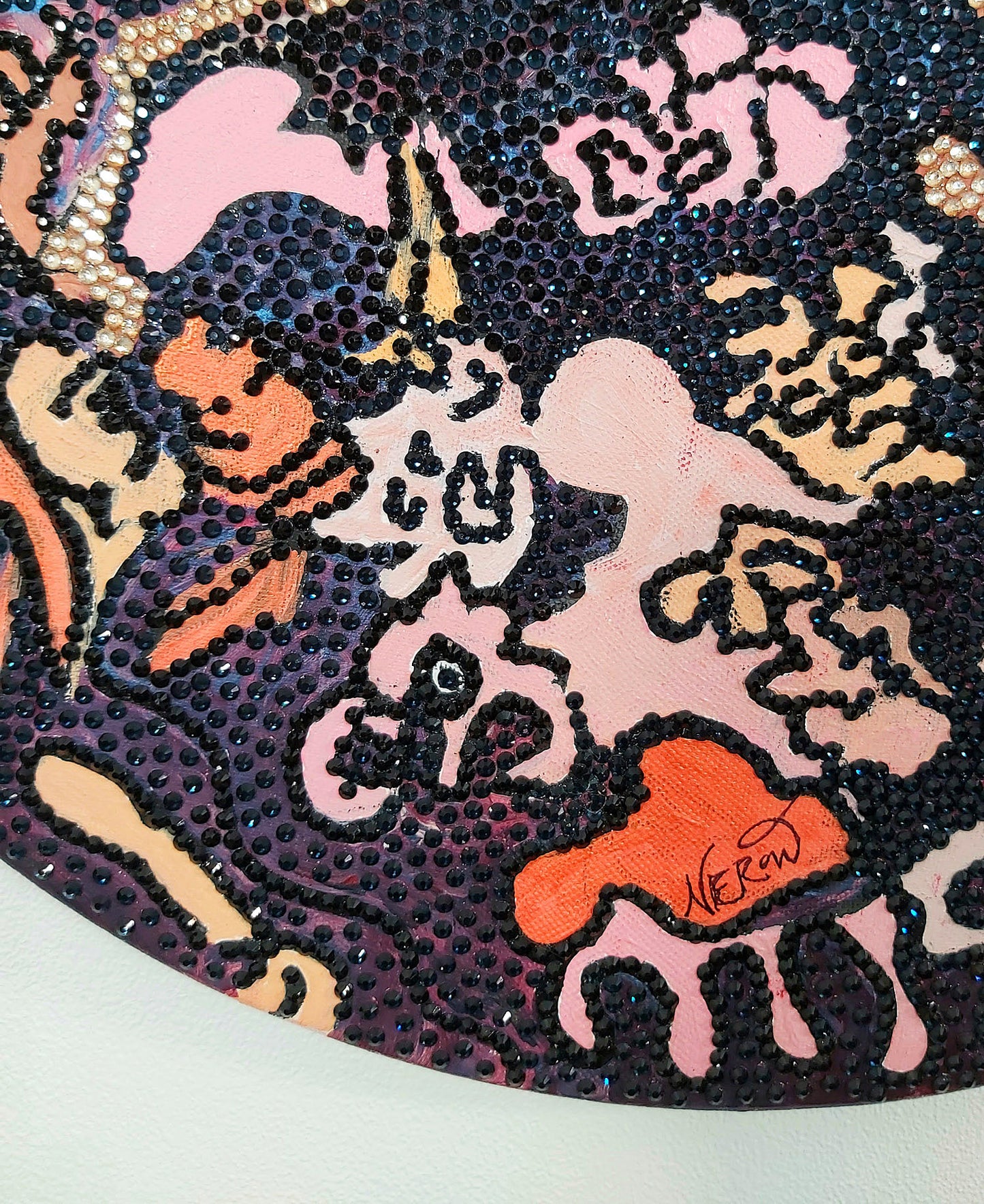 Artist Audrey Néron's signature on the artwork Mutatio Salvifica (2024), a circular abstract painting adorned with rhinestones, highlighting the artist's identity and authenticity within her Humans Landscape series.